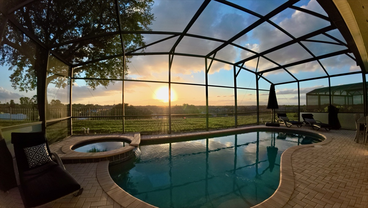 Heated saltwater pool at sunset behind a Time-Out Corner Vacations home — Windsor Hills Resort, Kissimmee, Florida
